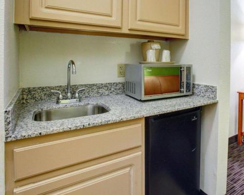 a kitchen counter with a sink and a microwave at Quality Inn & Suites Airport in Austin