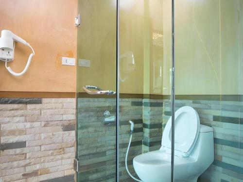 a bathroom with a toilet and a glass shower at Phi Phi Nice Beach Hotel Hip in Phi Phi Don