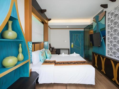 a bedroom with a bed and a blue wall at Phi Phi Nice Beach Hotel Hip in Phi Phi Don