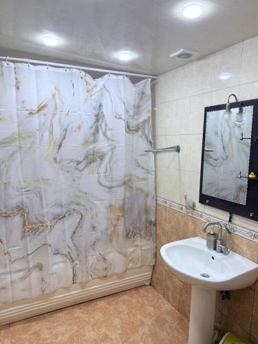 a bathroom with a shower curtain and a sink at SweetHome in Sevan