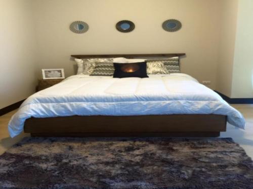 um quarto com uma cama grande e um tapete em Mactan Newtown Executive Studio em Mactan