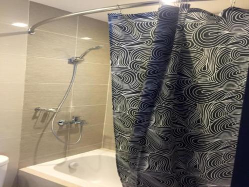 uma cortina de chuveiro na casa de banho com banheira em Mactan Newtown Executive Studio em Mactan