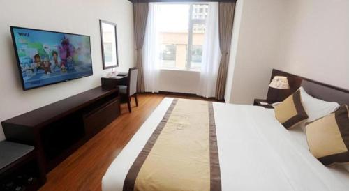 a hotel room with a bed and a flat screen tv at Lenid Hotel Tho Nhuom in Hanoi
