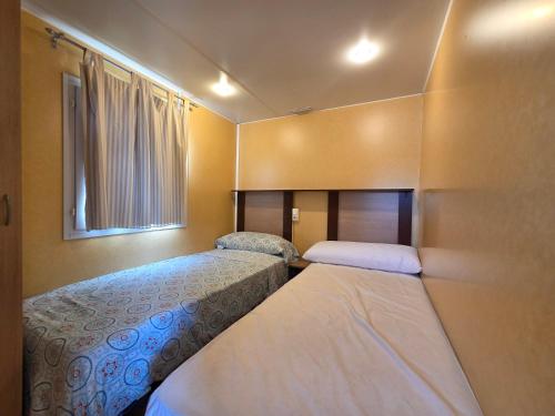 a small room with two beds and a window at Camping Albox in Albox