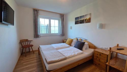 a bedroom with a bed and a desk and a window at Haus Tauernseitn in Schladming