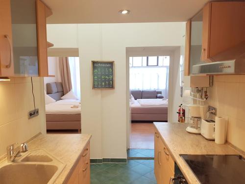 a kitchen with a sink and a living room at GASTEIN by ROCKCHAIR Apartments l SUPERHOST Status l 2 Bedrooms Boxspringbeds 1,5 Bathrooms - Cozy Family & Business Flair welcomes you! in Berlin