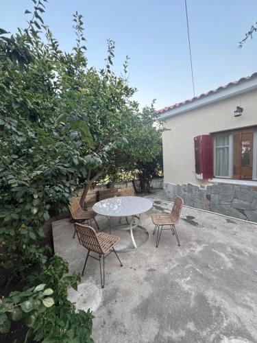 a patio with a table and chairs next to a building at 90m2 2 Bedroom Apartment in Myrina Center - Port of Myrina in Mirina
