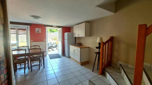 a kitchen and dining room with a table and a refrigerator at Gîte LE LOUP in Les Hautes-Rivières