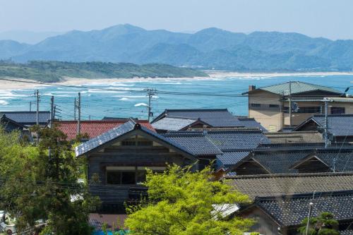 a group of houses with the ocean in the background at Ichiboukan Hanare Kai in Kyotango