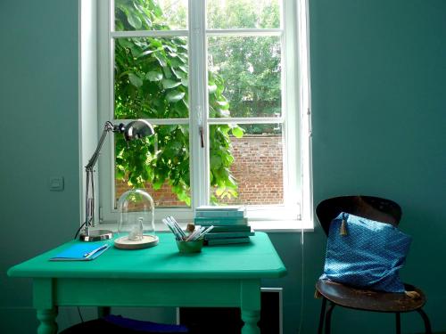 a green desk in front of a window at Queen Christine in Villeneuve d'Ascq