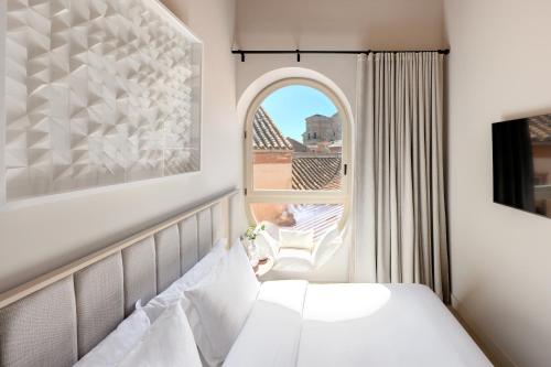 a hotel room with a bed and a window at Coeo Santa Maria Cathedral Signature Apartments in Málaga