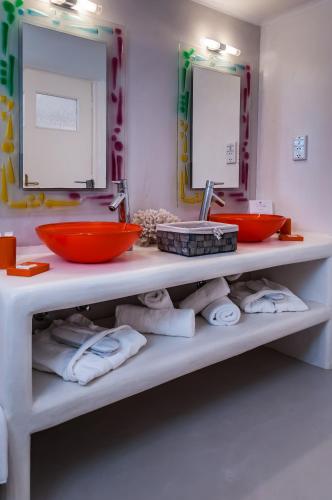 a bathroom with a counter with two sinks and towels at Eiriana Luxury Suites in Plaka Milou