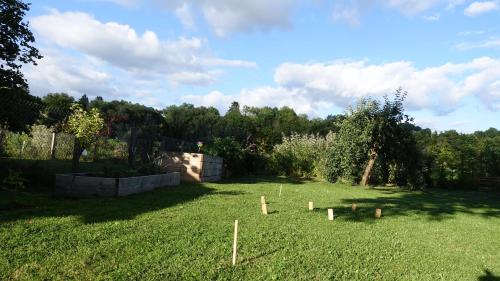 a yard with a garden with wooden posts in the grass at Hinkelshof - als Ferienwohnung - Selbstversorgerküche & Aufenthaltsräume - Südeifel, Mullerthal, Vianden in Körperich