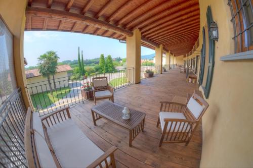イゼーオにあるAgriturismo Villa Antonellaの木製の天井、バルコニー(椅子、テーブル付)