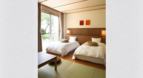 a bedroom with two beds and a window at Kyoto Keburikawa Hotel in Kameoka