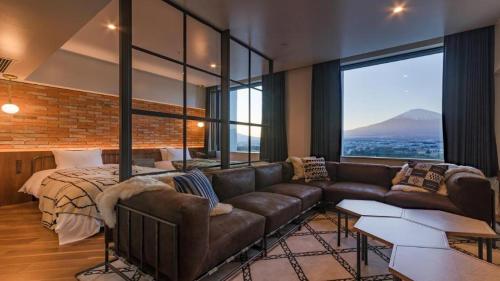 a living room with a leather couch and a bed at HOTEL CLAD in Fuji