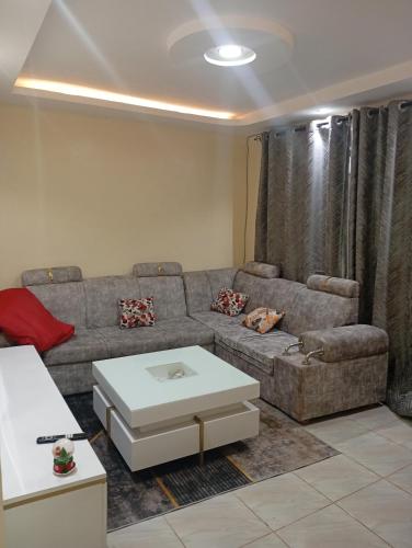 Una sala de estar con un sofá y una mesa de café. en Cynergy 1b Apartment, Muthiga , Waiyaki Way, en Nairobi