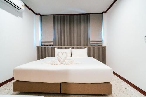 a bedroom with a white bed with a towel on it at on and on haus in Ban Na Nian