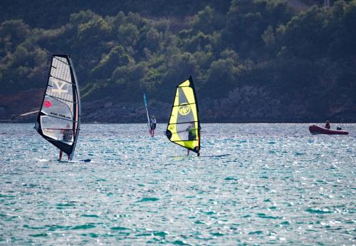 three people are windsurfing in the water at Agriturismo Ai Castioni in Molveno