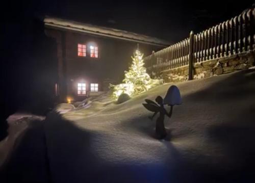 a snow covered yard with a christmas tree in the background at Atelier 1786 in Staldenried