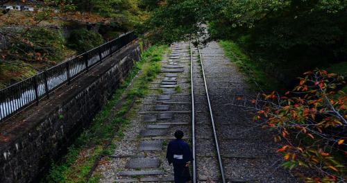 a man walking down a train track at Higashiyama Shikikaboku in Kyoto