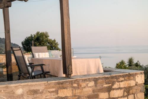 a table and a chair sitting on a stone wall at The Pelion Sunrise in Agios Ioannis Pelio