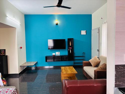 a living room with a blue wall at Samuels Comfort Homes in Bengaluru