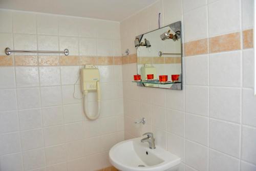 ein Badezimmer mit einem WC, einem Waschbecken und einem Spiegel in der Unterkunft Korali in Almiropótamos