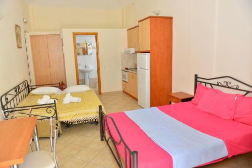 a bedroom with two beds and a kitchen at Korali in Almiropótamos