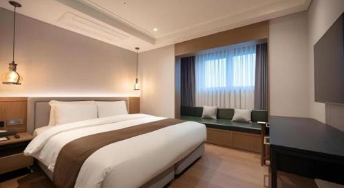 a bedroom with a large bed and a window at HOTEL D EDITION in Daejeon
