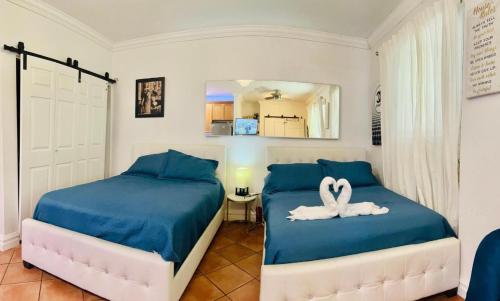 two beds with swans on them in a bedroom at south beach apartment 5 min walk to the ocean in Miami Beach