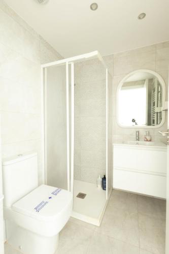 a white bathroom with a toilet and a sink at Soto de la Marina I Parking Privado I Wifi I Playa in Soto de la Marina