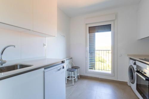 a white kitchen with a sink and a dishwasher at Soto de la Marina I Parking Privado I Wifi I Playa in Soto de la Marina