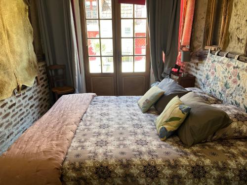une chambre avec un lit et une fenêtre dans l'établissement La Maison aux Volets Rouges, à La Ferté-Beauharnais