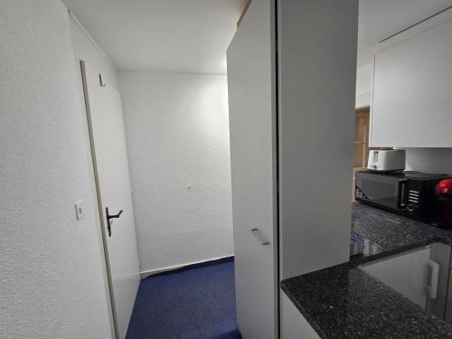 a room with a kitchen with a door and a microwave at Real Swiss Classic Apartment & Up to 7 Seats Cars Rental Option in Bern