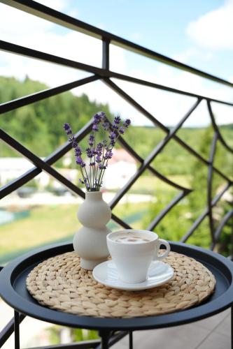 スキュネイザにあるForrest Hotelの花瓶とコーヒーを楽しめるテーブル