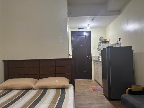 a bedroom with a bed and a black door at Stanford Suites 3, staycation near Nuvali, located in Silang in Bayabasan