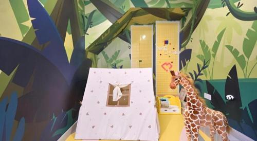 a toy giraffe standing next to a toy house at Huafa Executive Apartment Hotel Zhuhai in Zhuhai