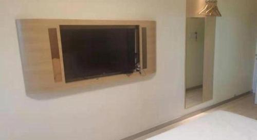 a flat screen tv hanging on a wall at 7 Days Inn Changchun Zhengyang Street Changchun Park Branch in Changchun