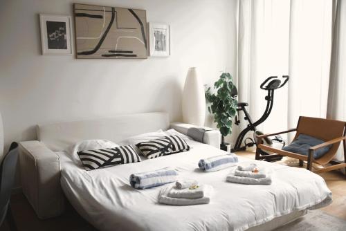 a bedroom with a white bed with pillows on it at Modern & Sunny 1BR Apartment with swimming pool in Luxembourg