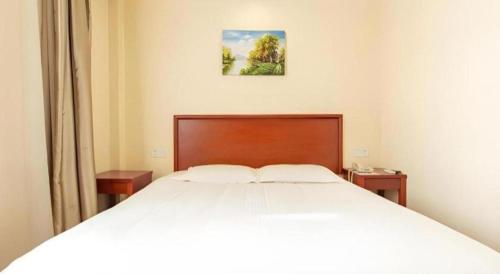 a bedroom with a large white bed and two tables at GreenTree Inn Nanjing Confucius Temple Sanshan Street Subway Station Express Hotel in Nanjing