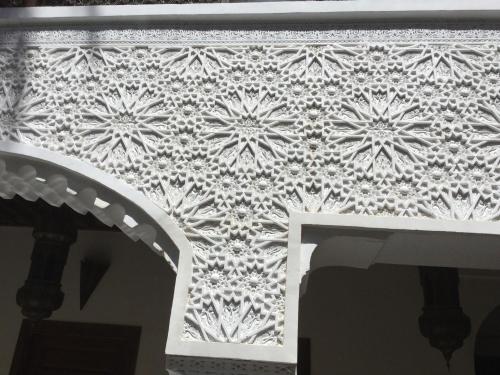 a stenciled wall with a floral pattern on a wall at Riad Zanzibar in Marrakech