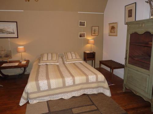 een slaapkamer met een bed met 2 kussens bij Le point d'orgue in Pineuilh
