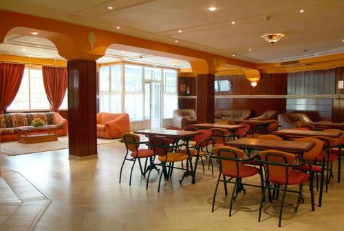 un restaurante con mesas y sillas en una habitación en Hotel Cabañas en Puertollano