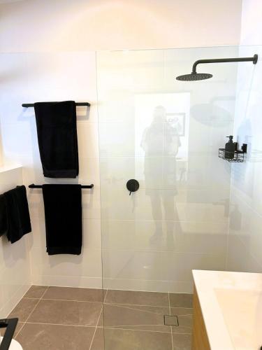 a person standing in a shower in a bathroom at Stunning Modern Self-contained Apartment in Beaumont