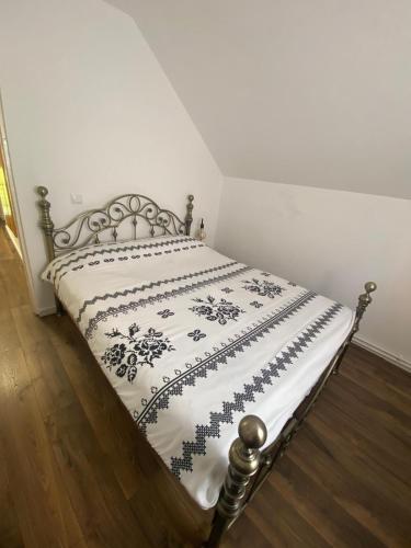a bed with a black and white blanket on it at Cabana Revnic in Băişoara
