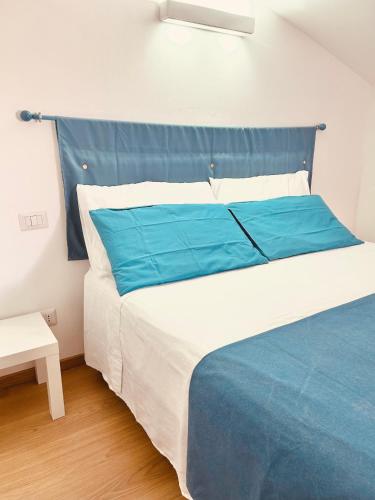 a large bed with a blue headboard in a room at Nanni's House in Quartu SantʼElena