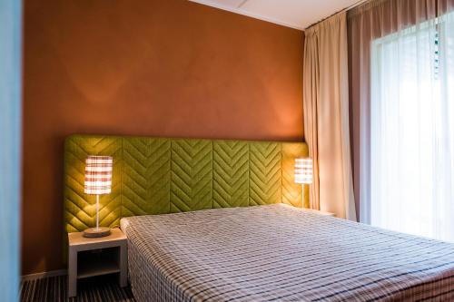 - une chambre avec un lit et deux lampes sur une table dans l'établissement Kuressaare Marina Apartment, à Kuressaare