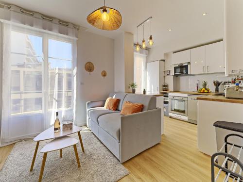 un salon avec un canapé et une cuisine dans l'établissement City Center - Magnificent Apartment - Cozy - Wifi, à Nice