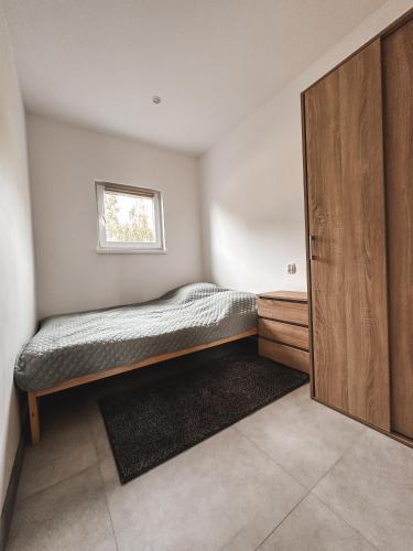 a small bedroom with a bed and a window at U Tomasza in Śliwin